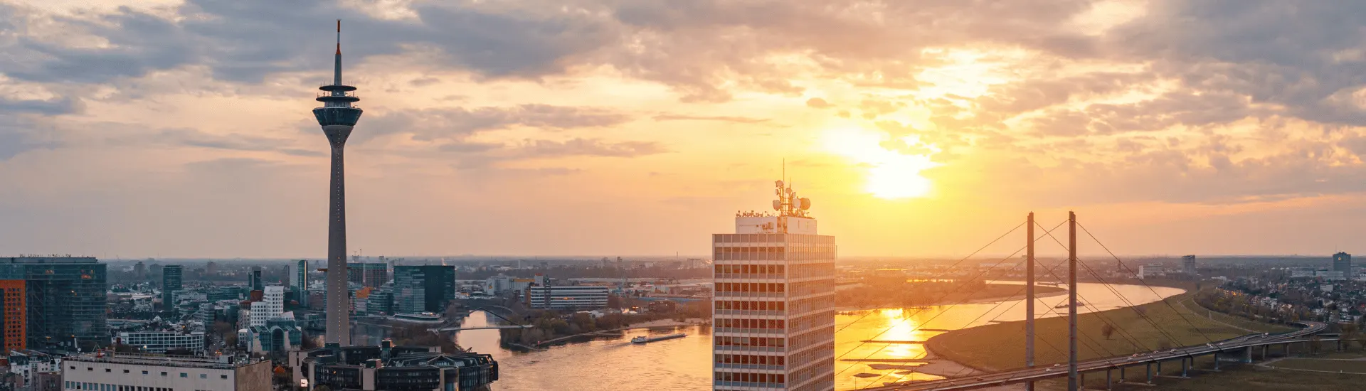 Hausmeisterdienste von Immobilien Service Mauss für die Instandhaltung Ihrer Immobilien in Düsseldorf und Umgebung. Sonnenuntergang über den Büroflächen von Düsseldorf am Rhein.