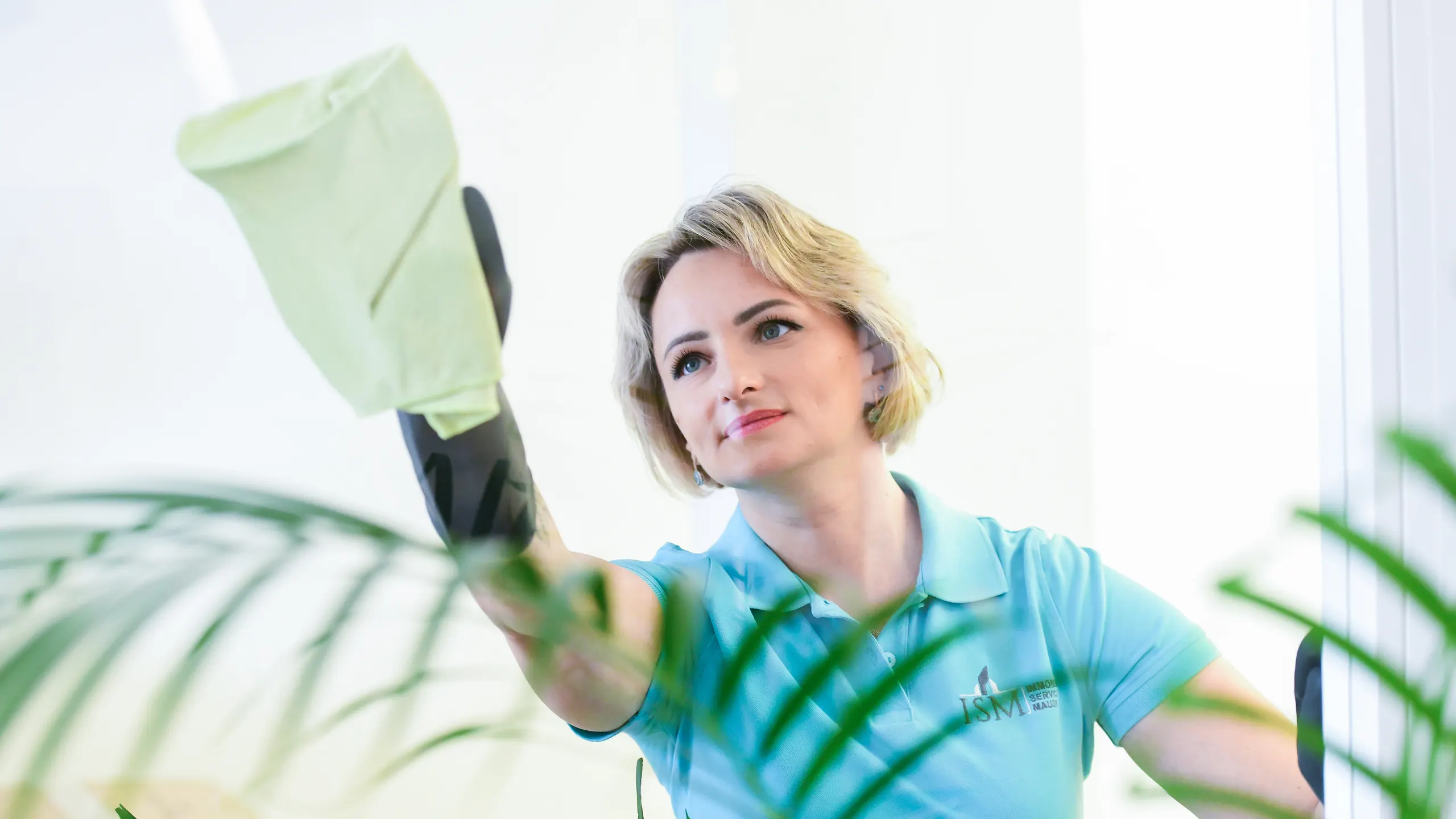 Fachkraft des Immobilien Service Mauss bei der gründlichen Reinigung einer Glasfläche – Teil des umfassenden Facility-Management-Services.